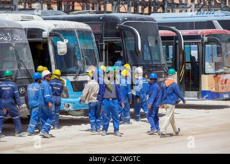 I lavoratori si imbarcarono per il trasporto per portarli a mensa per il pranzo mentre lavorano alla costruzione di un importante stabilimento petrolifero nel deserto del Sahara. Foto Stock