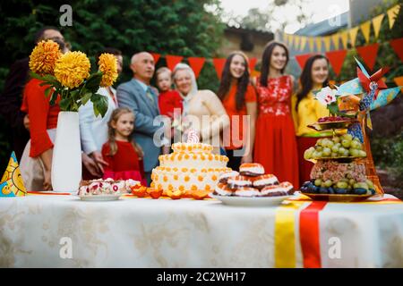 Festa di compleanno della famiglia bambino fuori nel backyard.Big giardino festa. Fuoco selettivo sulla torta con una candela 5 anni Foto Stock