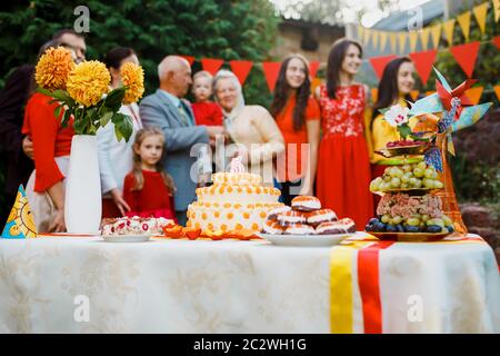 Festa di compleanno della famiglia bambino fuori nel backyard.Big giardino festa. Fuoco selettivo sulla torta con una candela 5 anni Foto Stock