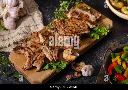 Deliziose grigliate di carne condita con aglio e pepe, insalata fresca Foto Stock