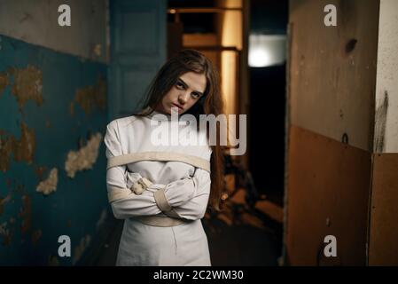 Pazza paziente femminile in camicia stretto, ospedale mentale. Donna in camicia di forza in trattamento in clinica per i malati mentali Foto Stock