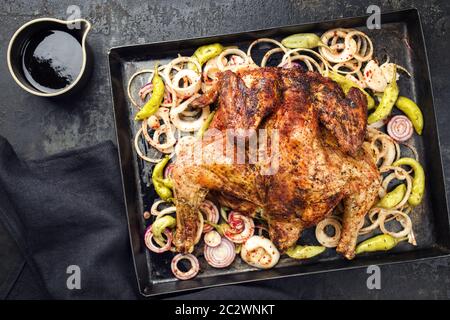 Barbecue pollo al mattone choccato barbecue chili con peperoni e cipolle come vista dall'alto su un vecchio foglio di metallo Foto Stock