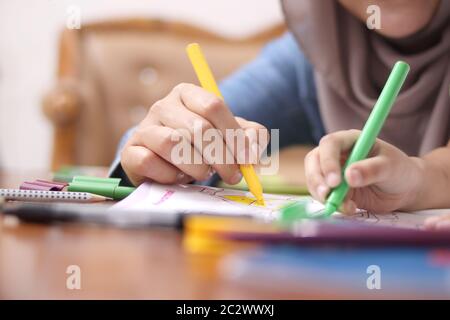 Madre musulmana asiatica che disegnano con sua figlia, mamma single che insegna bambina, concetto di famiglia felice Foto Stock