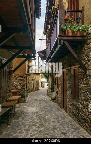 Antico villaggio Kakopetria a Cipro - architettura di viaggio sfondo. Vista mozzafiato sulla strada nella città vecchia. Pentole con fiore Foto Stock