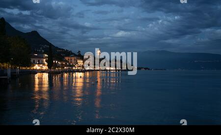 Vista in tarda serata del Grand Hotel Gardone con luci che si riflettono nel lago Foto Stock