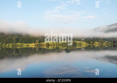 Mattina presto Mist sopra il lago di Grasmere, Lake District, Cumbria, Regno Unito Foto Stock