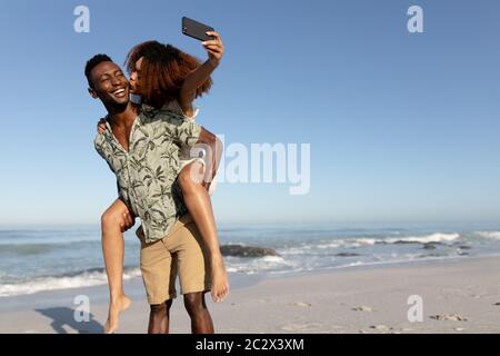 Coppia felice prendendo un selfie sulla spiaggia Foto Stock