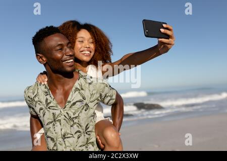 Coppia felice prendendo un selfie sulla spiaggia Foto Stock