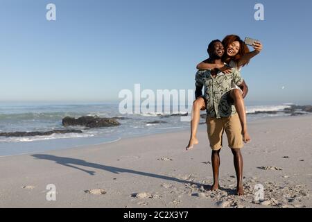 Coppia felice prendendo un selfie sulla spiaggia Foto Stock