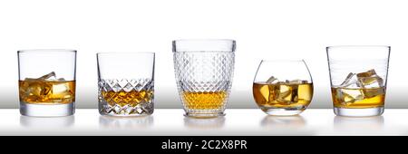 Una barra bianca con una fila di bicchieri da whisky di stile diverso e ghiaccio, isolata su bianco con un leggero riflesso Foto Stock