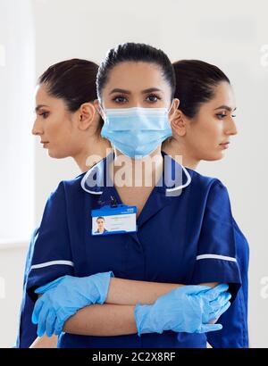 Ritratto dell'infermiere che indossa una maschera e guanti PPE Foto Stock