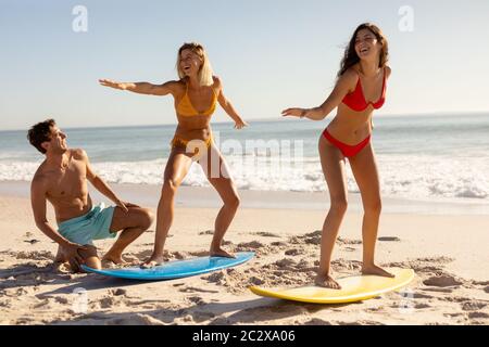 Gruppo caucasico di amici che navigano sulla spiaggia Foto Stock