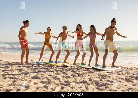 Gruppo multietnico di uomini e donne, surf sulla spiaggia Foto Stock