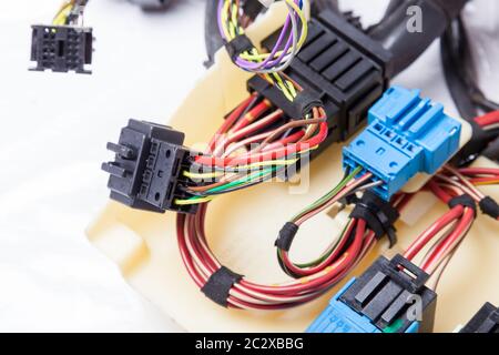 Fili elettrici multicolore con connettori per auto su sfondo bianco isolato durante la riparazione della rete da parte di un tecnico o meccanico in assistenza o in riparazione Foto Stock