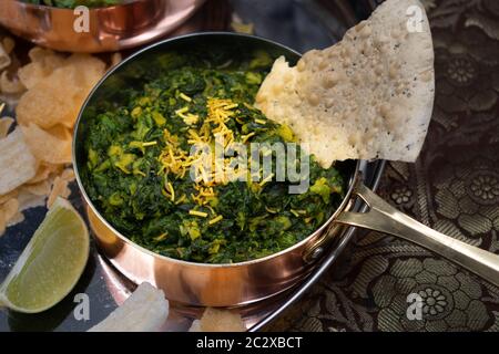 Spinaci vegani e lenticchie dell'India del Nord in una ciotola tradizionale Foto Stock