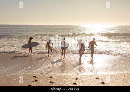 Gruppo multietnico di uomini e donne, surf sulla spiaggia Foto Stock