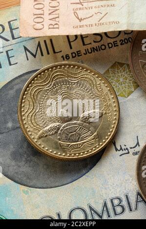 Primo piano delle monete colombiane sulla banconota Foto Stock