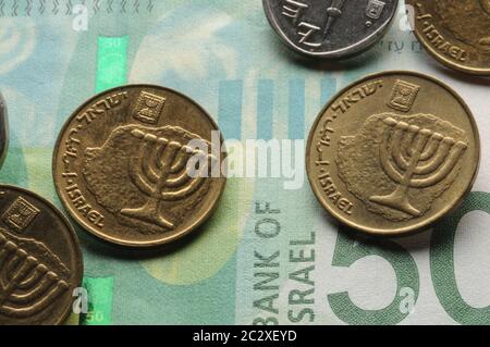 Primo piano delle monete israeliane sulla banconota Foto Stock