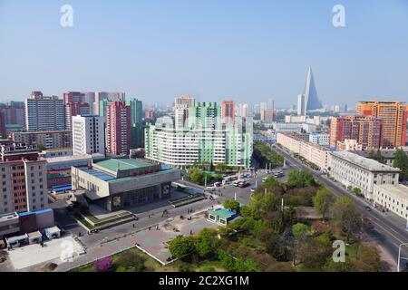 Corea del Nord, Pyongyang - 1 maggio 2019: Vista sulla città, viali, quartieri moderni e cinema edificio in primo piano con l'Arco di Trionfo Foto Stock