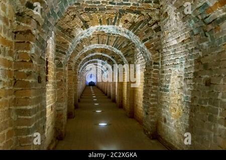 Arco in mattoni rossi come passaggio tra le due ali di un castello medievale. Granito pietra un mattone costruito interno Foto Stock