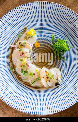 Vista dall'alto delle capesante non elaborate. Piatto di sashimi freschi crudi. Il sashimi è una specialità della cucina giapponese che consiste in carne grezza tagliata a fette (di solito pesce e frutti di mare Foto Stock