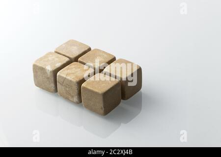 Set di sei pietre di raffreddamento spiritose. Le rocce di pietra ollare sono scolpite in cubetti da utilizzare come chiller di bevande (whisky, bourbon, ecc). Vari tipi di minerale grezzo Foto Stock