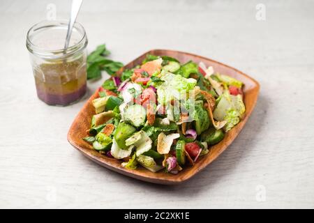 Piatto di insalata e condimento Fattoush. L'ingrediente chiave di questo piatto medio orientale è il pane tostato pita che è mescolato con verdure sane Foto Stock