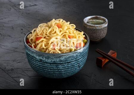 Tagliatelle istante con verdure, con amore e bastoncini, un close-up su sfondo scuro Foto Stock