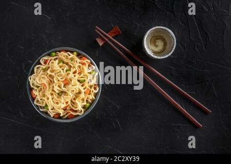 Tagliatelle istante con verdure, con amore e bastoncini, girato dalla parte superiore su uno sfondo scuro con un posto per il testo Foto Stock