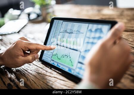 Close-up di imprenditore analizzando il mercato azionario lo stato sulla tavoletta digitale Foto Stock