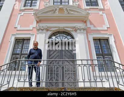 12 giugno 2020, Brandeburgo, Groß Rietz: Percy Bongers, proprietario del castello di Groß Rietz, si trova di fronte all'edificio barocco. "Non sono il signore del castello, ma l'arte", dice Percy Bongers. Il suo amore per il castello barocco Groß Rietz (Oder-Sprea) iniziò dieci anni fa, quando la casa padronale, che fu costruita intorno al 1700 ed è un edificio storico, era ancora un grande cantiere. La Brandenburgische Schlösser GmbH aveva preso il controllo della proprietà con la sua façade rosa e bianca dal comune a metà degli anni '90 per salvarla da ulteriore decadimento. Più di cinque milioni di euro sono confluiti nei restaurati Foto Stock