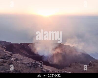 Fumoso scenario del cratere di vulcano Stromboli vicino la Sicilia al tempo di sera Foto Stock