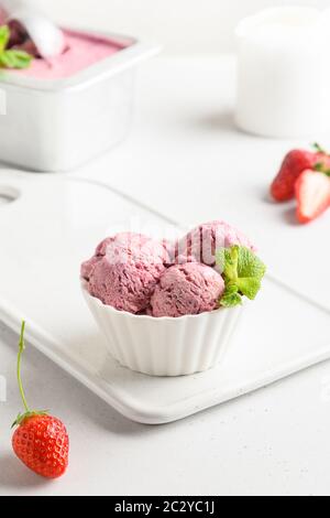 Gelato alla fragola in ciotole su bianco. Foto Stock