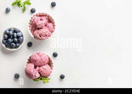 Gelato alla frutta e alla bacca, sorbetto in ciotole su sfondo bianco. Vista dall'alto. Spazio di copia Foto Stock