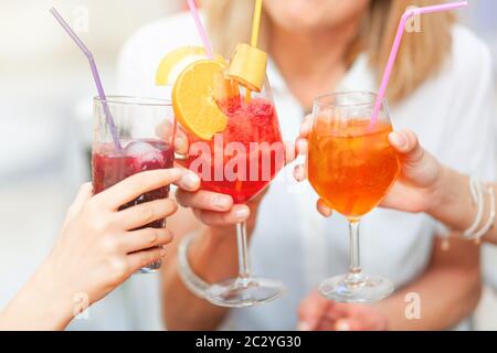 Cheers con diversi cocktail colorati, rosso spritz, mirtillo e orange spritz. Foto Stock