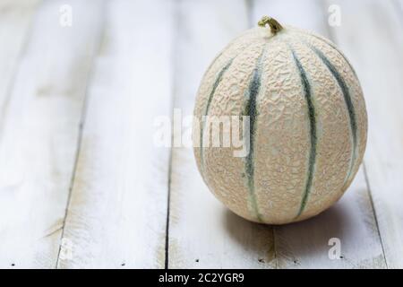 Melone di miele su sfondo bianco di legno. Foto Stock