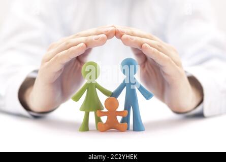 Concetto di assicurazione di famiglia con figurine colorate della famiglia coperte dalle mani Foto Stock