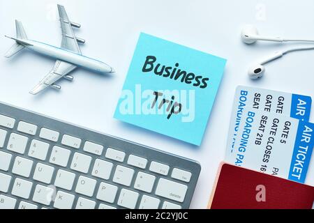 L'iscrizione sull'adesivo viaggio di lavoro accanto a biglietti, un aeroplano giocattolo e un passaporto Foto Stock