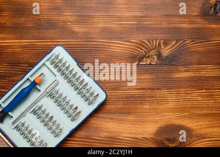 Set di cacciaviti con ugelli su fondo in legno. Spazio di copia e vista superiore Foto Stock