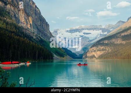 Vista laterale del battello a remi rosso sul lago tranquillo, Banff, Alberta, Canada Foto Stock