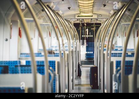 All'interno del treno a vagone Germania, Dusseldorf. Interno del treno vuoto. Vista interna del corridoio all'interno dei treni passeggeri con fa blu Foto Stock