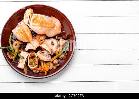 Calamari farciti con funghi, carote e peperoni. Frutti di mare Al Forno con verdure Foto Stock