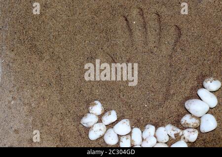 Stampa a mano su simbolo sabbia con pietra bianca, primo piano spiaggia di sabbia dorata, concetto di vacanza estiva. Messa a fuoco selettiva con sfocatura . Foto Stock