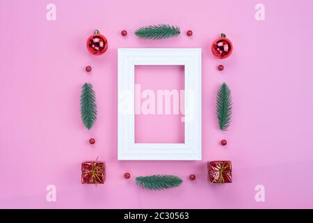 Vacanze di Natale composizione, vista dall'alto di rosso le decorazioni di Natale e cornice immagine su sfondo rosa con copia spazio per il testo. Piatto, laici inverno, Foto Stock