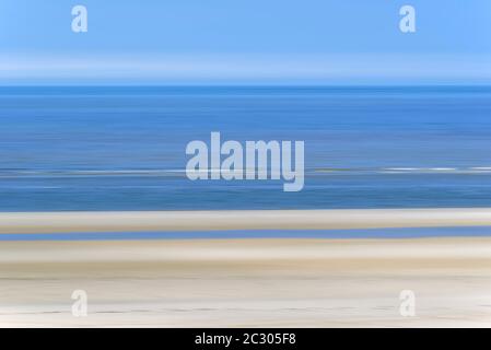 Spiaggia di sabbia con onde in arrivo e cielo blu, effetto pulente, Wangerooge, Ostfriesische Inseln, Mare del Nord, bassa Sassonia, Germania Foto Stock