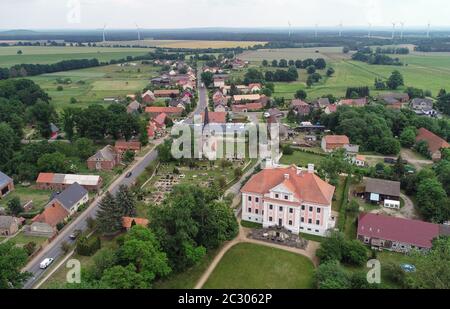 12 giugno 2020, Brandeburgo, Groß Rietz: Il castello Groß di Rietz con la chiesa del villaggio e il cimitero (vista aerea con un drone). "Non sono il signore del castello, ma l'arte", dice Percy Bongers. Il suo amore per il castello barocco Groß Rietz (Oder-Sprea) iniziò dieci anni fa, quando la casa padronale, che fu costruita intorno al 1700 ed è un edificio storico, era ancora un grande cantiere. La Brandenburgische Schlösser GmbH aveva preso il controllo della proprietà con la sua façade rosa e bianca dal comune a metà degli anni '90 per salvarla da ulteriore decadimento. Più di cinque milioni di euro sono stati versati al restor Foto Stock