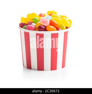 Jellybeans fruttato. Gustosi e colorati fagioli di gelatina in tazza di carta isolato su sfondo bianco. Foto Stock