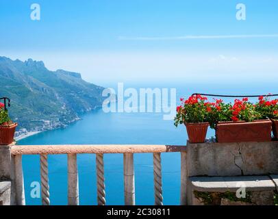 Vista dalla terrazza di Villa Cimbrone con gerani rossi fioriti in vasi di terracotta che si affacciano sul Mar Tirreno, Ravello, Campania, Italia Foto Stock