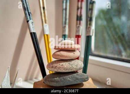 Pila di pietre e bastoncini di tritare sullo sfondo Foto Stock