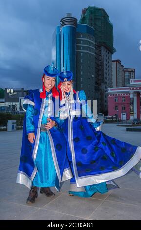 Una giovane coppia mongolo vestita in costume tradizionale Khalkh per le strade della città di Ulaanbaatar, Mongolia Foto Stock